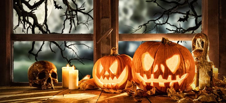 Fun Ways to Decorate Your Porch for Halloween, Spooky halloween pumpkins on wooden planks, placed in front of window with scary background