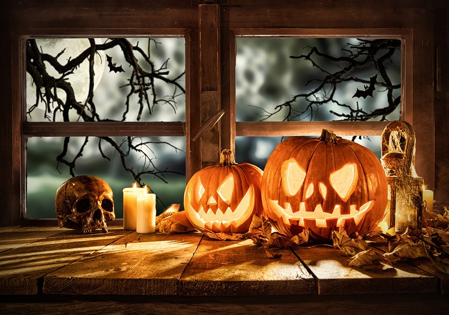 Fun Ways to Decorate Your Porch for Halloween, Spooky halloween pumpkins on wooden planks, placed in front of window with scary background